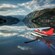 A seaplane landing on a tranquil lake surrounded by mountains